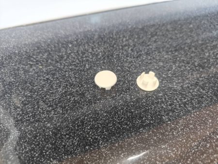 Step 1 - Carefully remove the white plastic plugs covering the top two holes with diagonal cutters and then remove all four of the screws holding the aluminum cover to the refrigerator